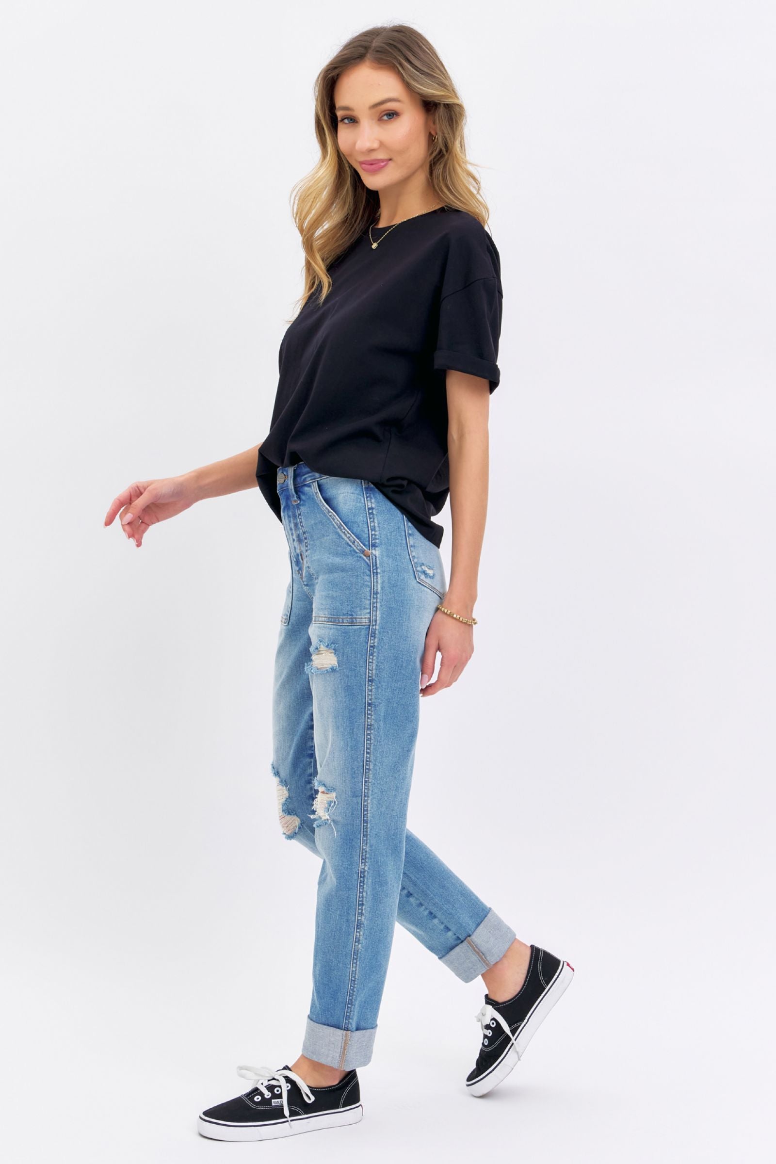 Woman wearing Judy Blue Jeans distressed cuffed boyfriend denim with black t-shirt and sneakers