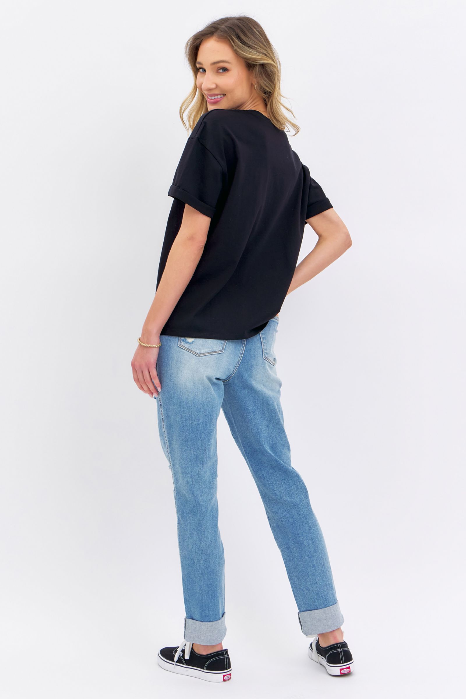 Woman wearing Judy Blue Jeans high rise distressed cuffed boyfriend denim jeans with a black t-shirt and sneakers