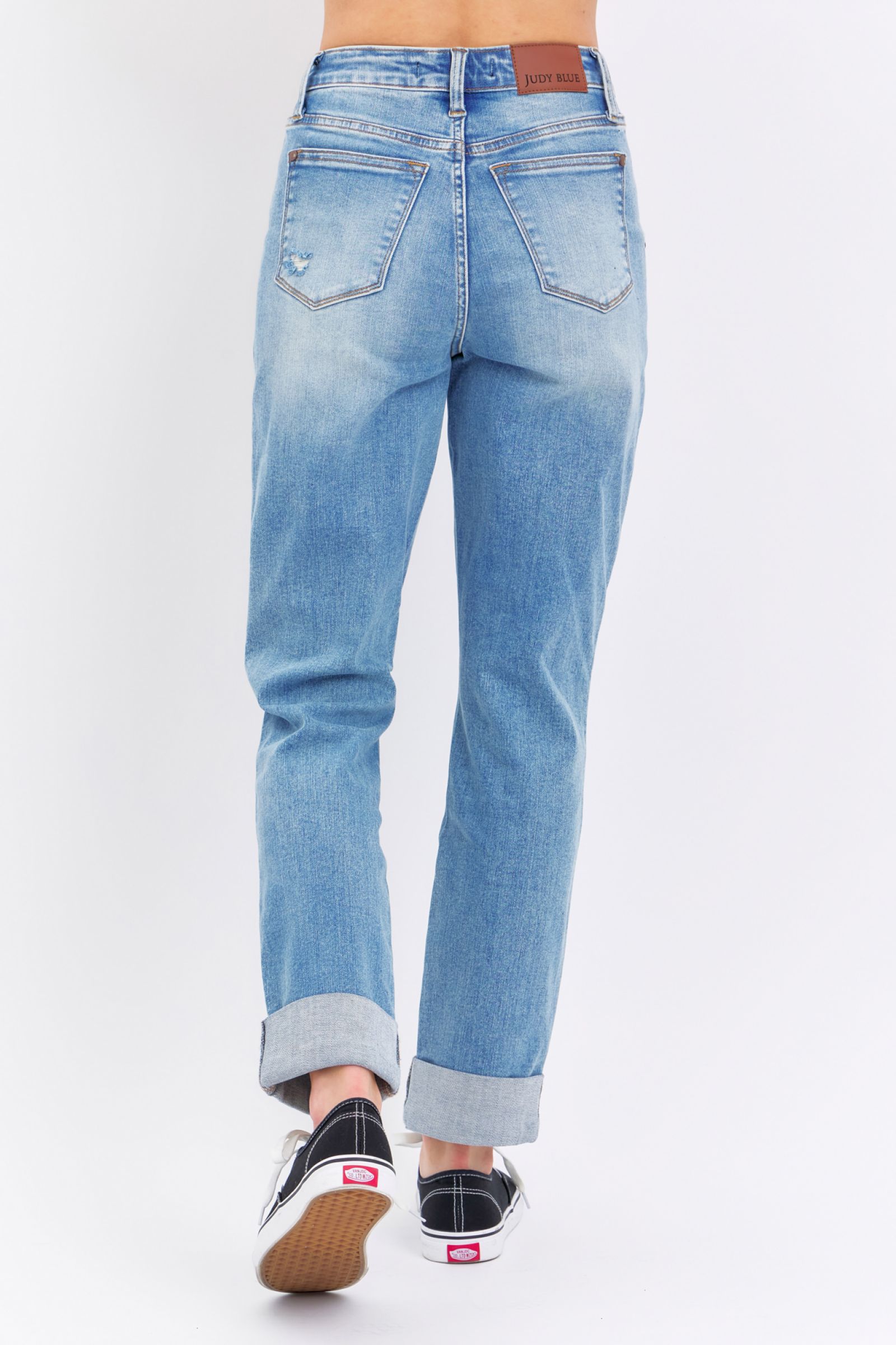 Back view of cuffed high-rise distressed Judy Blue Jeans 88825 on model wearing black and white sneakers