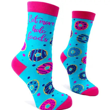 Women's novelty socks with colorful donut design and "Eat More Hole Foods" pun text on bright blue background with pink accents.