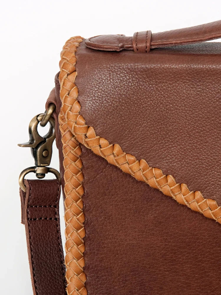Close-up of American Darling Small Crossbody messenger bag in genuine full grain leather with braided trim and adjustable strap