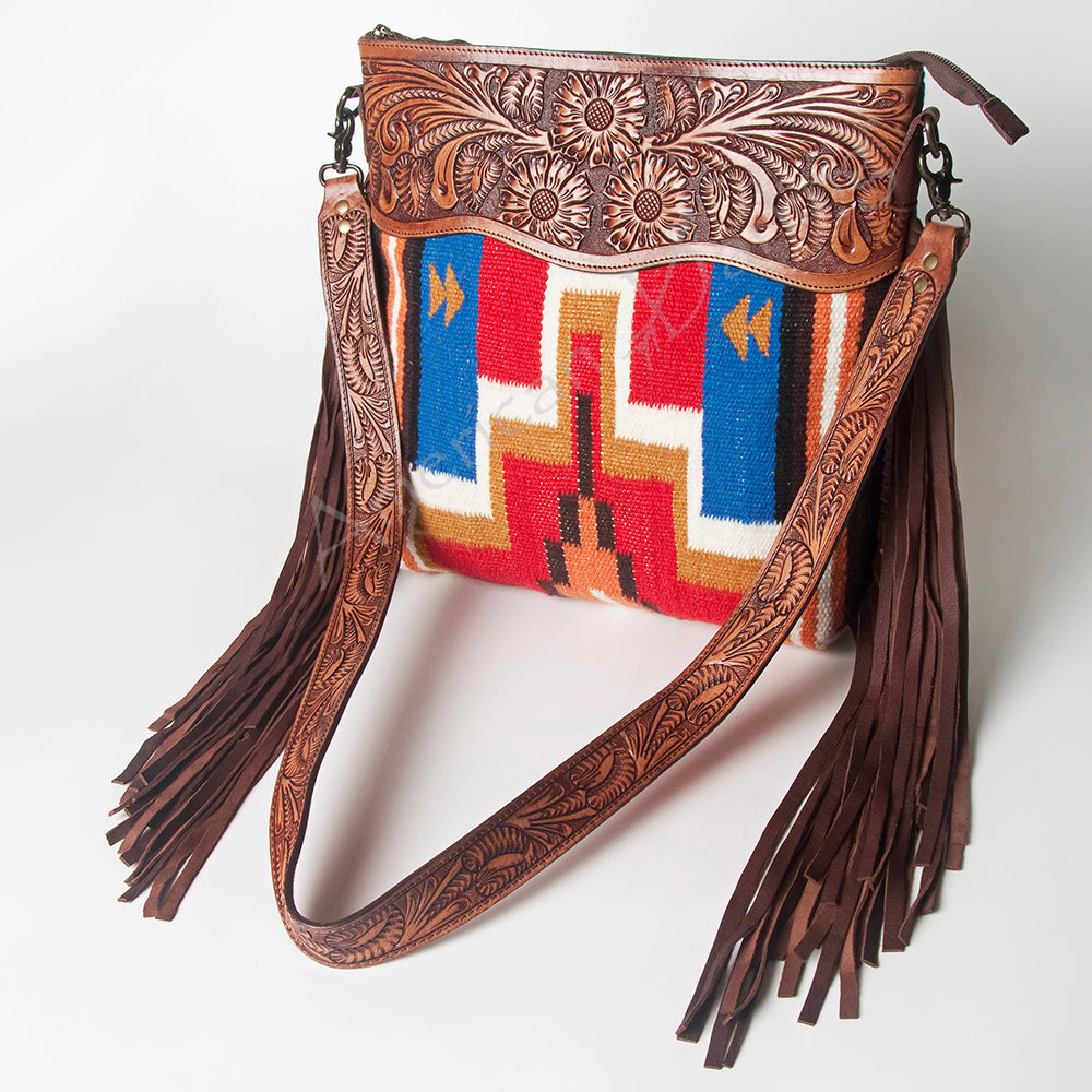 American Darling crossbody messenger bag with hand-tooled leather strap, fringes, and woven wool saddle blanket in vibrant western design