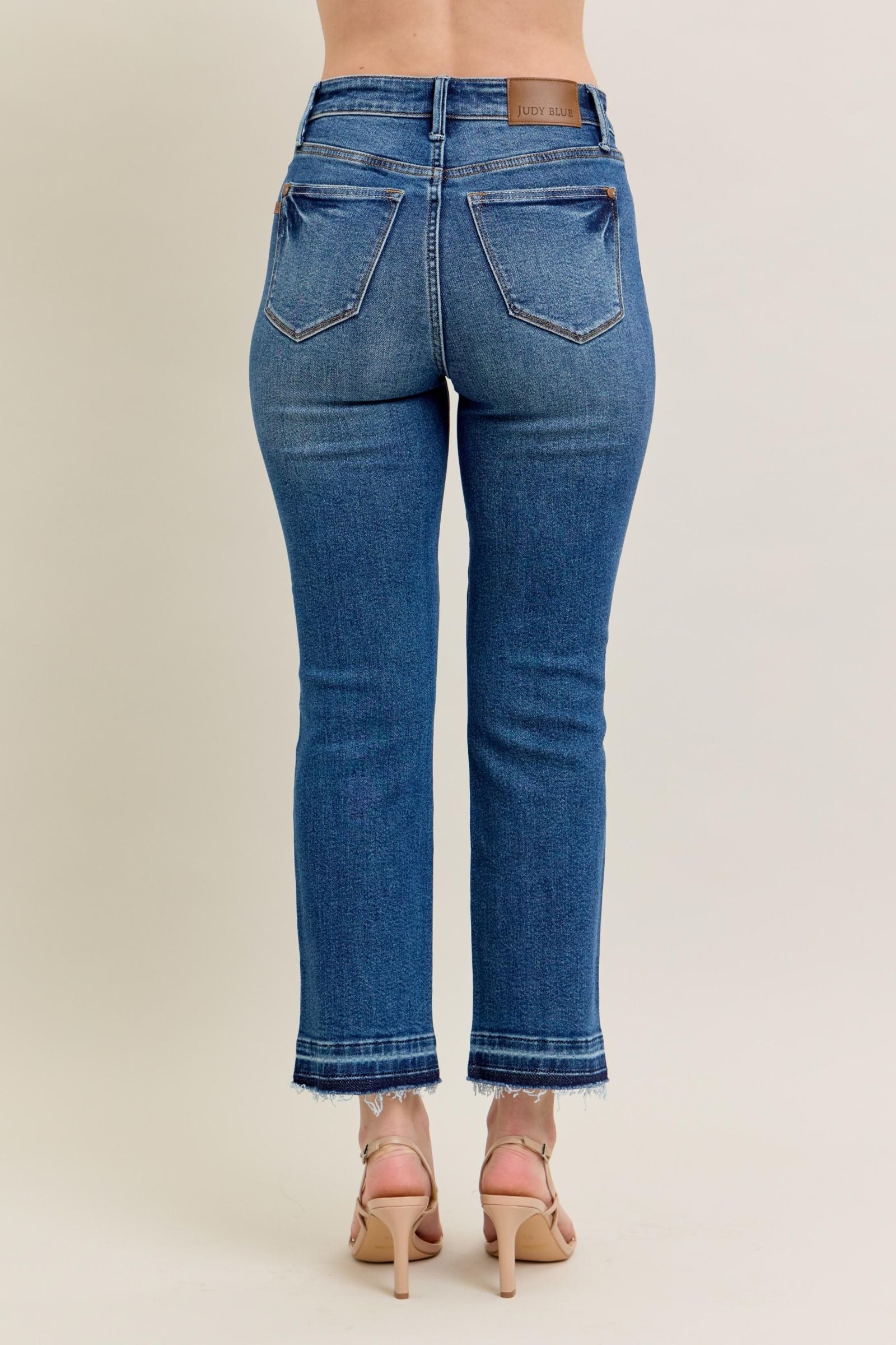 High-rise Judy Blue Jeans with vintage wash, kick flare, and raw hem.
