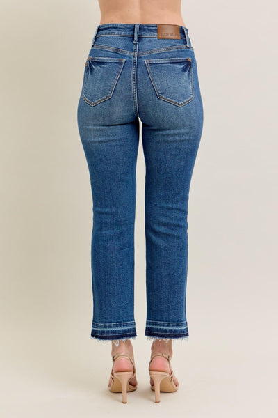 High-rise Judy Blue Jeans with vintage wash, kick flare, and raw hem.