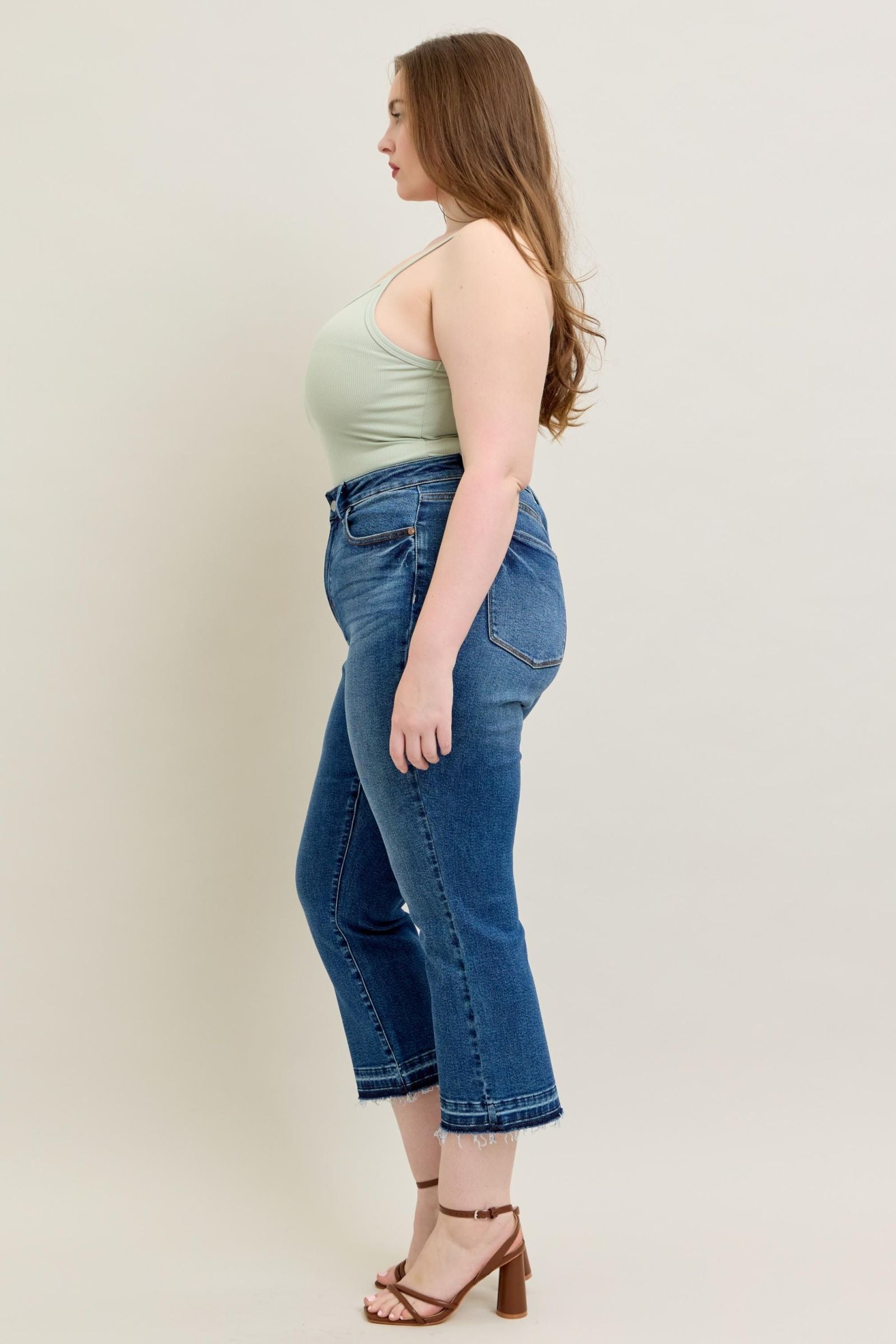 High-rise Judy Blue Jeans with vintage wash and modern kick flare, side view on model.