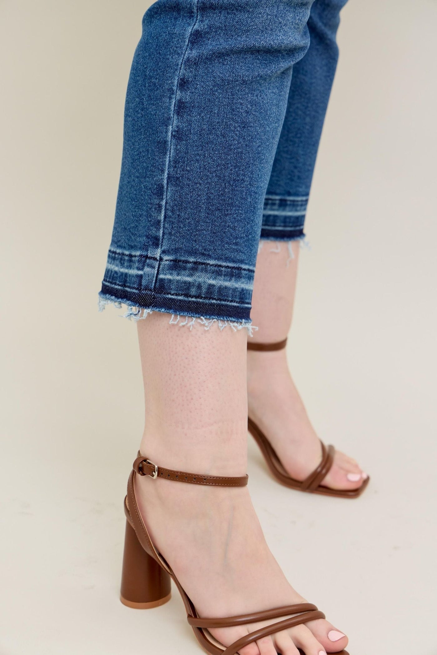 Judy Blue Jeans with vintage wash and raw release hem, showing kick flare silhouette.