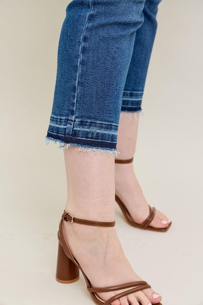 Judy Blue Jeans with vintage wash and raw release hem, showing kick flare silhouette.