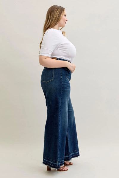 Plus size model wearing Judy Blue high waist palazzo jeans with a wide-leg cut and dark wash denim