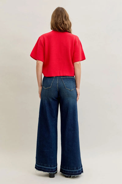 Back view of model wearing Judy Blue Jeans 881046 high waist palazzo wide-leg jeans with rear patch pockets and a red cropped top
