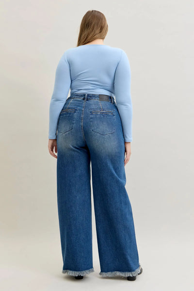 Plus size model wearing high waist Judy Blue Jeans with straight leg and back welt pockets, styled with light blue long sleeve top.