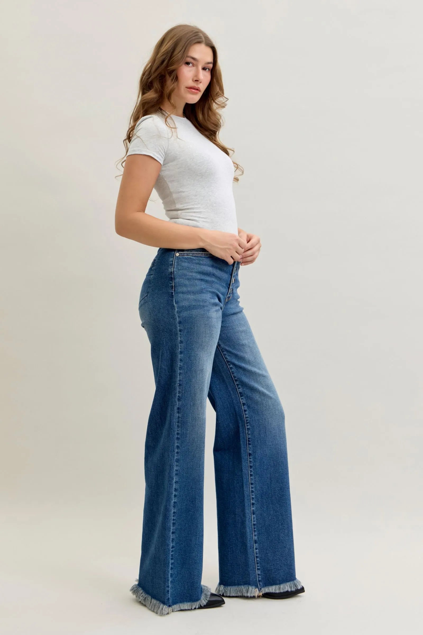 Woman wearing high waist Judy Blue Jeans 881001 with straight-leg fit and button-fly closure