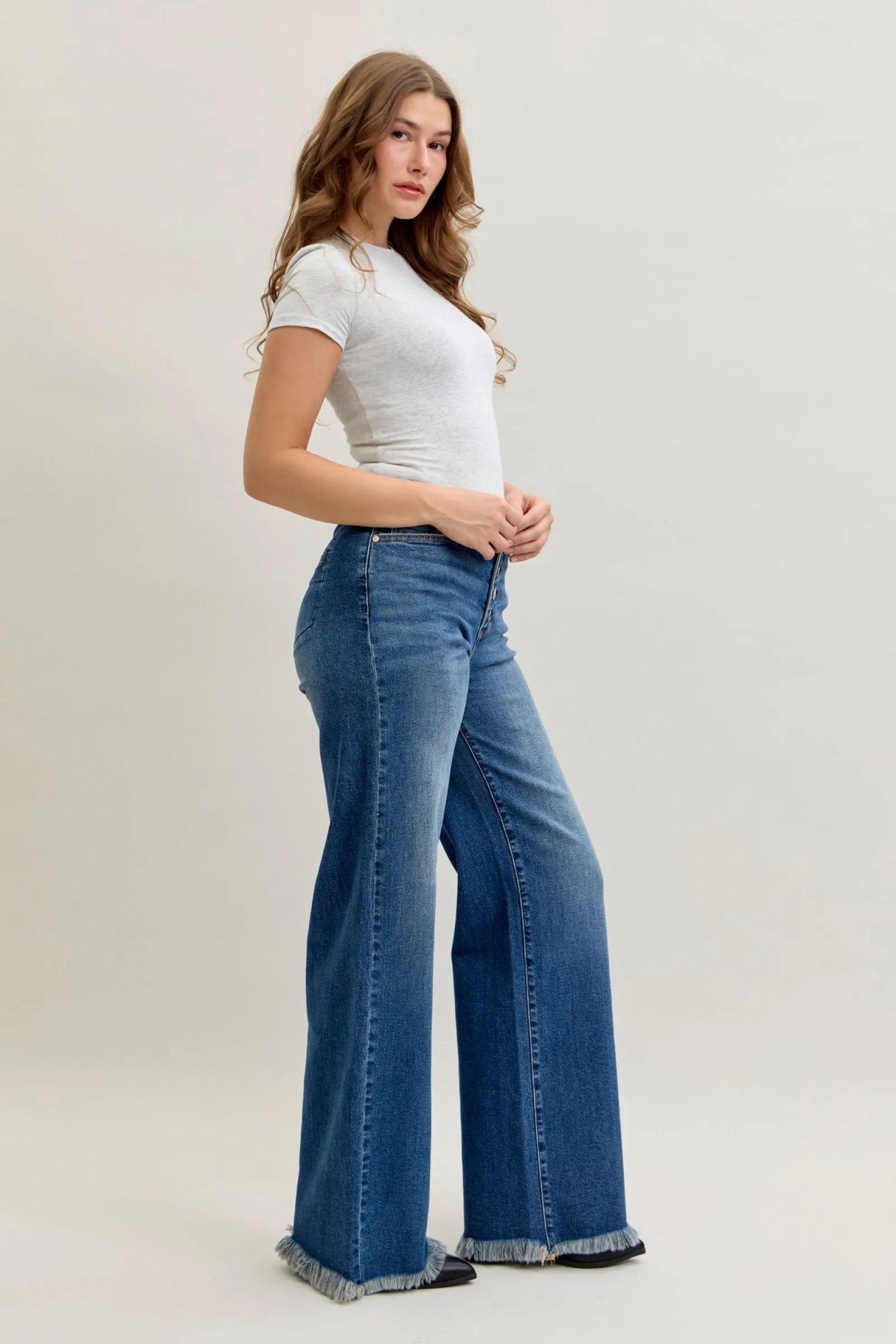 Woman wearing high waist Judy Blue Jeans 881001 with straight-leg fit and button-fly closure