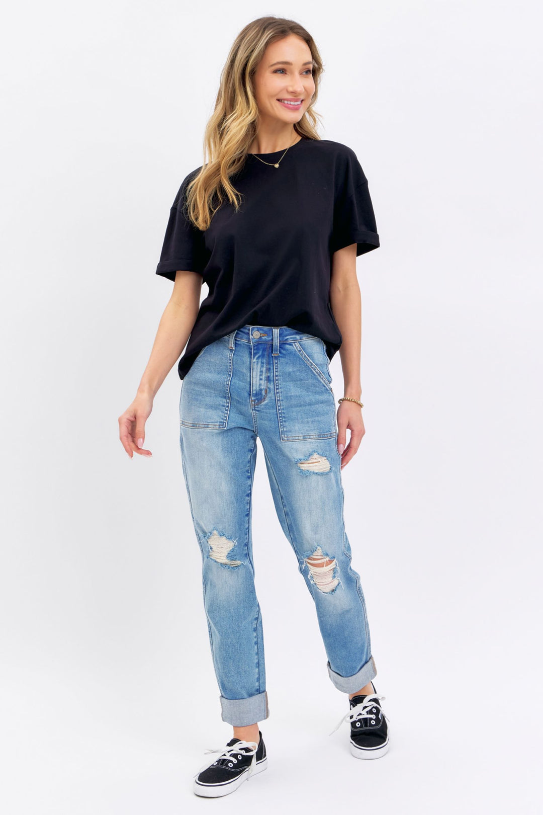 Woman wearing high rise distressed cuffed Judy Blue Jeans with black t-shirt and sneakers