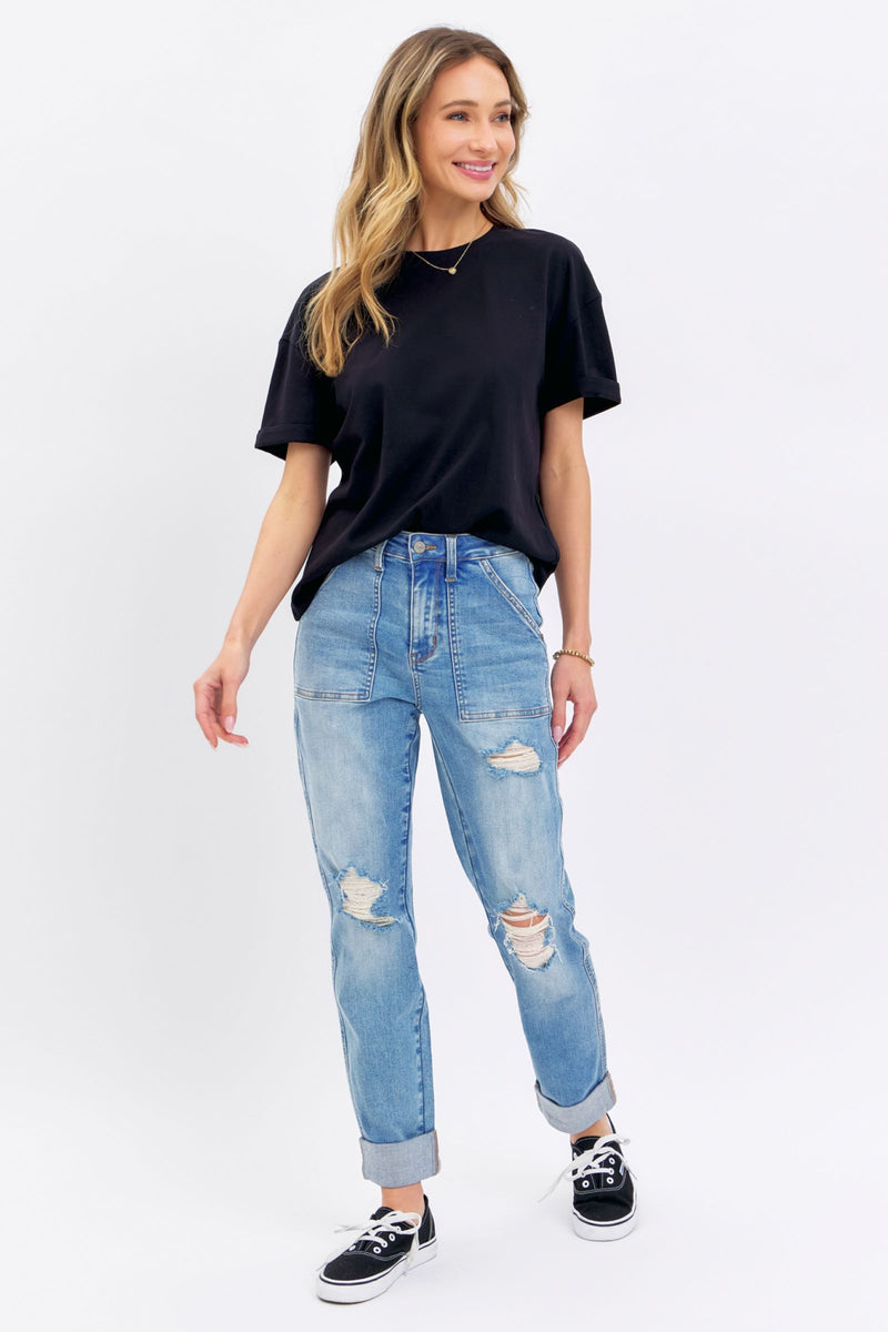 Woman wearing high rise distressed cuffed Judy Blue Jeans with black t-shirt and sneakers