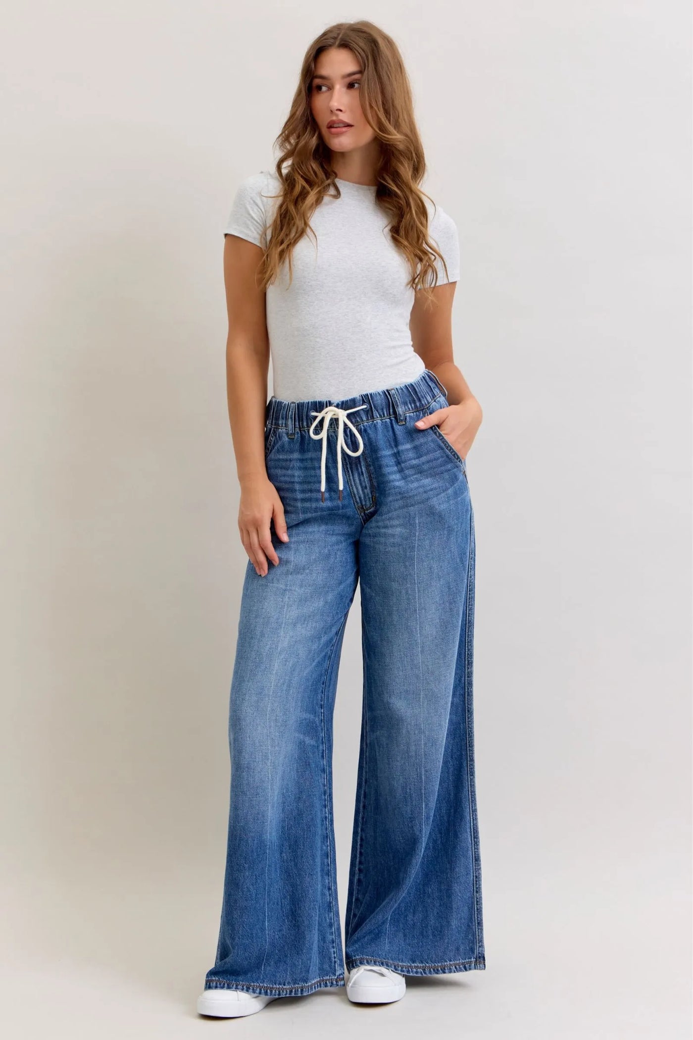 Woman wearing Judy Blue Jeans high waist featherweight palazzo jeans with elastic waistband and wide-leg cut