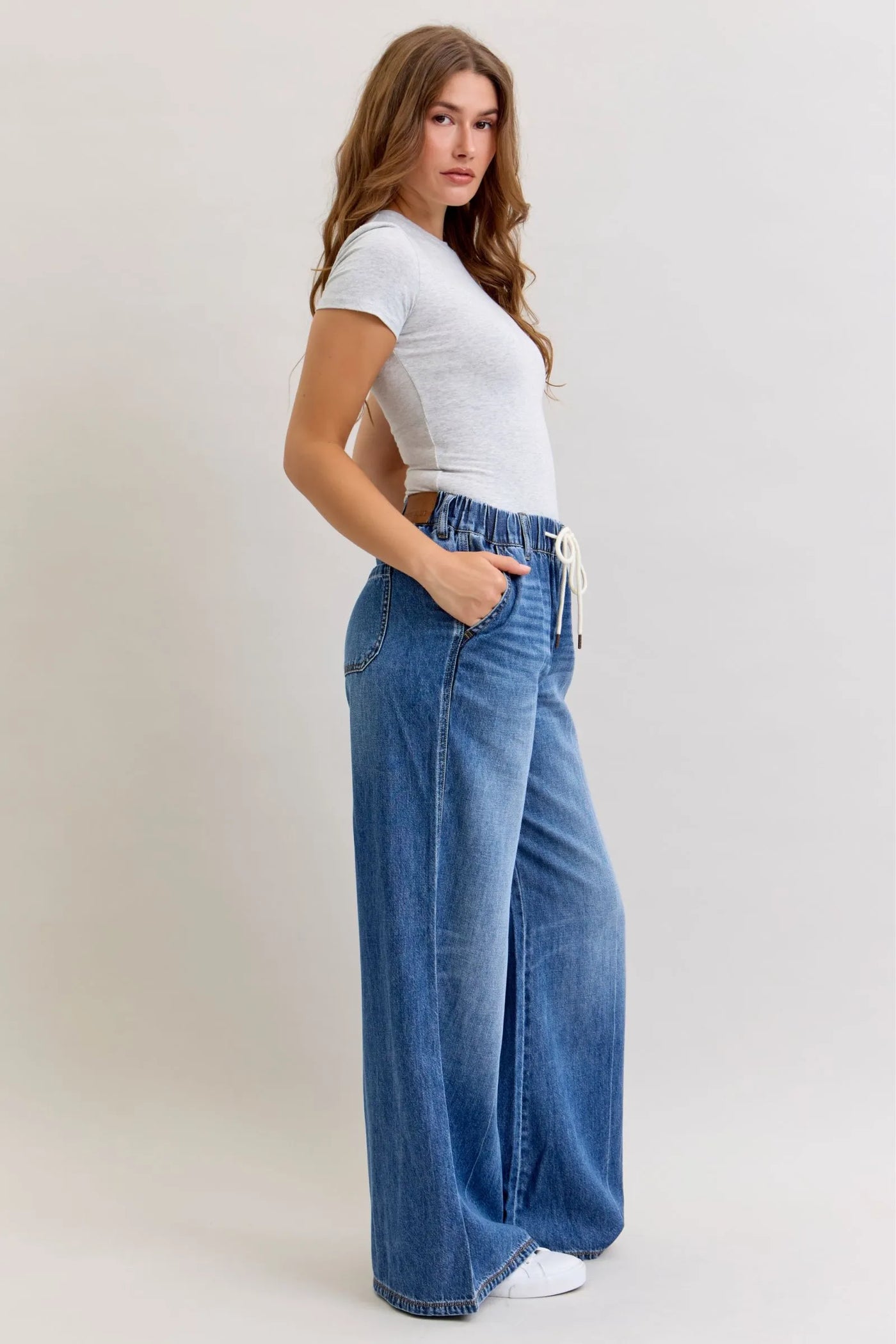 Woman wearing Judy Blue Jeans high waist featherweight palazzo jeans with elastic waistband and wide leg cut