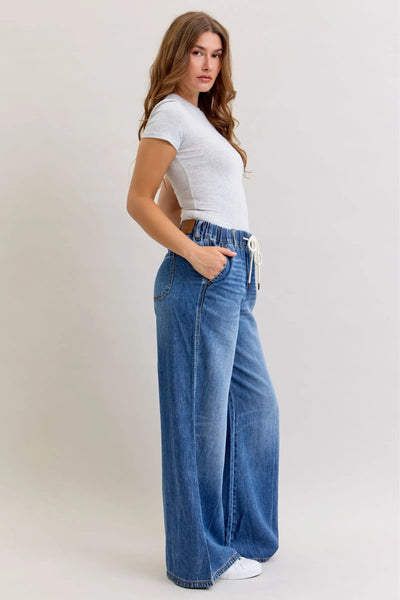 Woman wearing Judy Blue Jeans high waist featherweight palazzo jeans with elastic waistband and wide leg cut