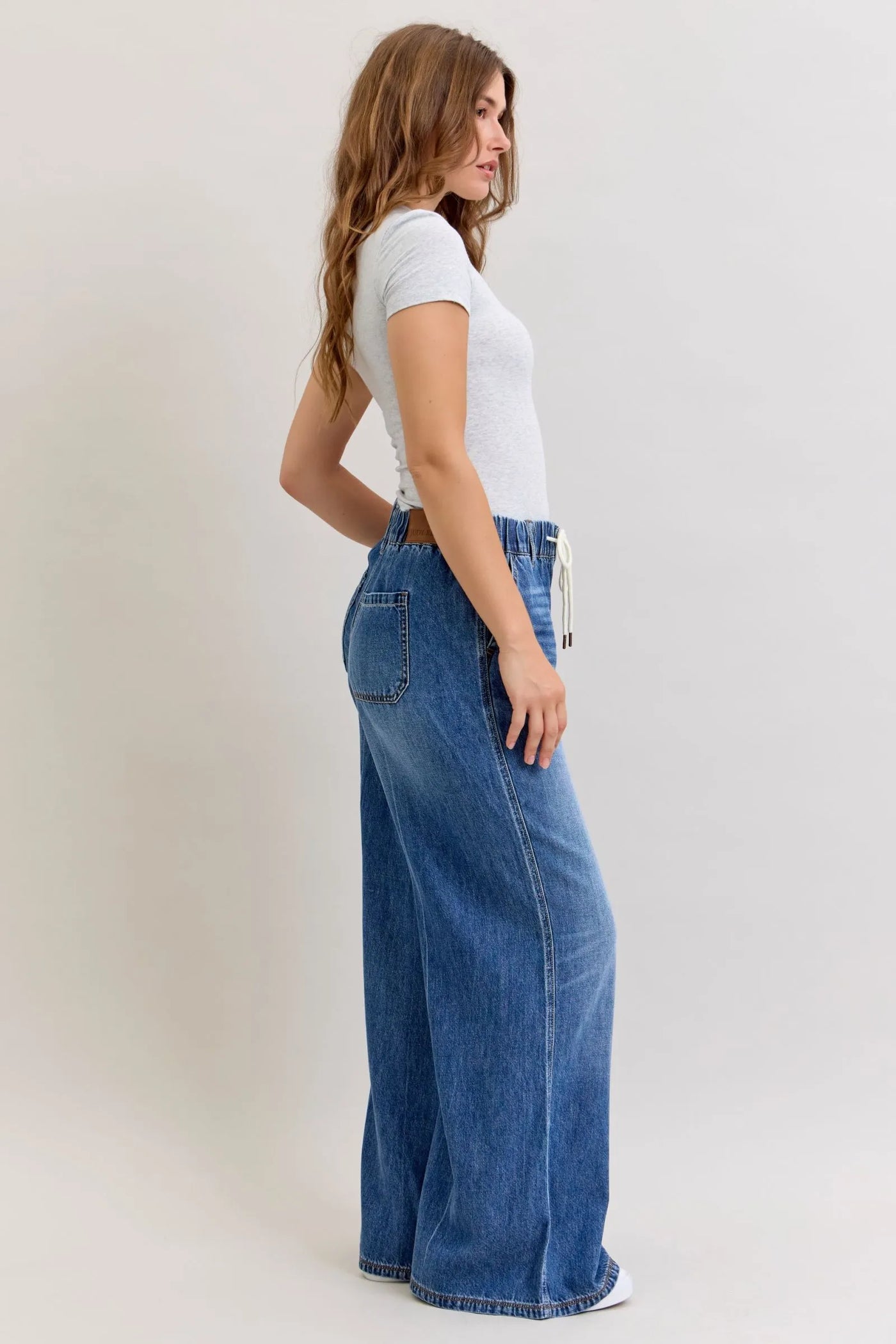 Woman wearing high waist Judy Blue Jeans 881016 palazzo denim with elastic waistband and wide legs