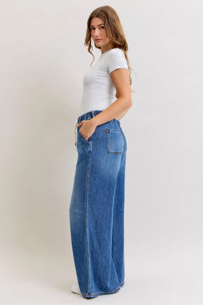 Woman wearing high waist elastic waistband Judy Blue Jeans palazzo cut denim pants