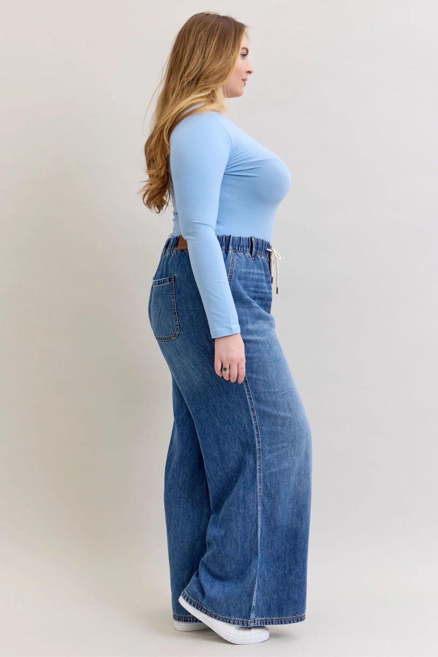 Plus size model wearing Judy Blue Jeans 881016 high waist featherweight palazzo jeans with elastic waistband and wide leg cut