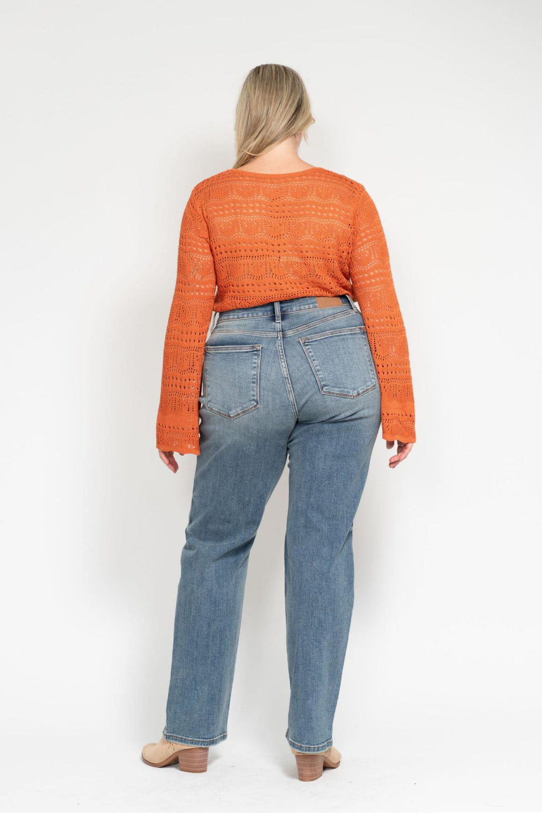 Woman wearing high waist dad straight Judy Blue Jeans 82641 with harsh tint and destroyed details, styled with orange sweater