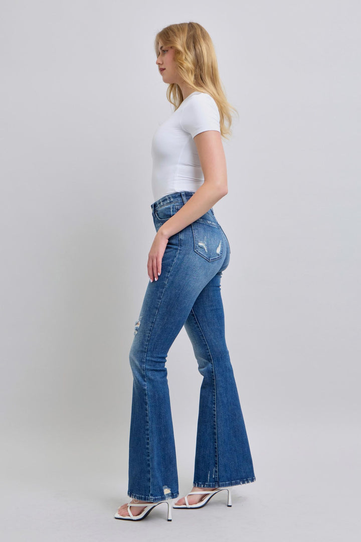 Woman wearing high waist contrast wash destroyed flare Judy Blue Jeans 88383 with white top and heels in side view