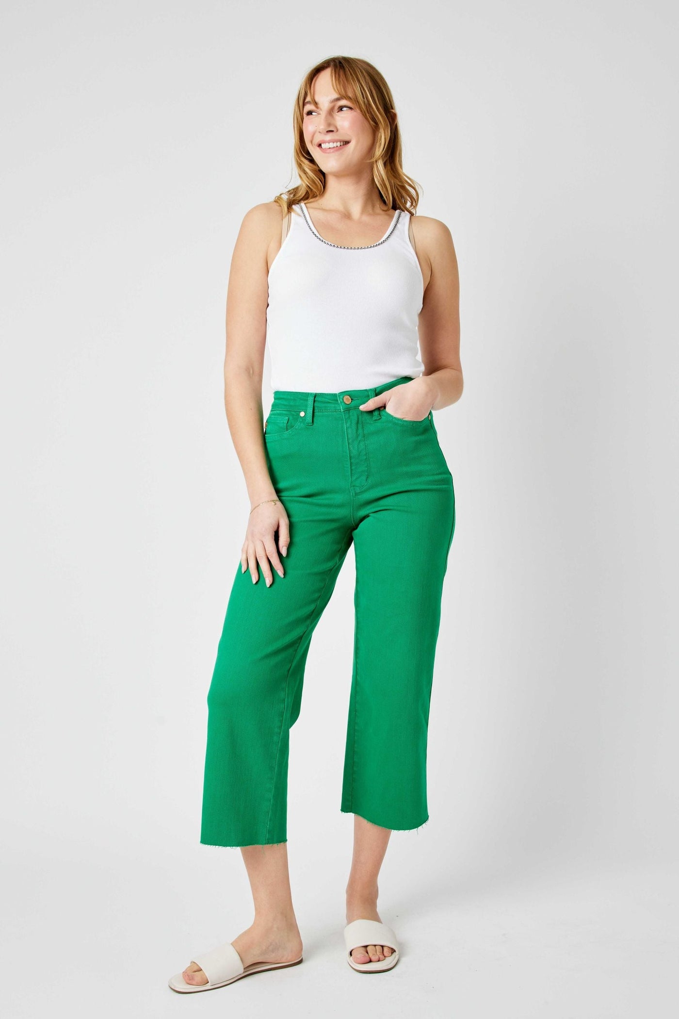 Woman wearing high waist Kelly green wide leg crop Judy Blue Jeans with white tank top and sandals