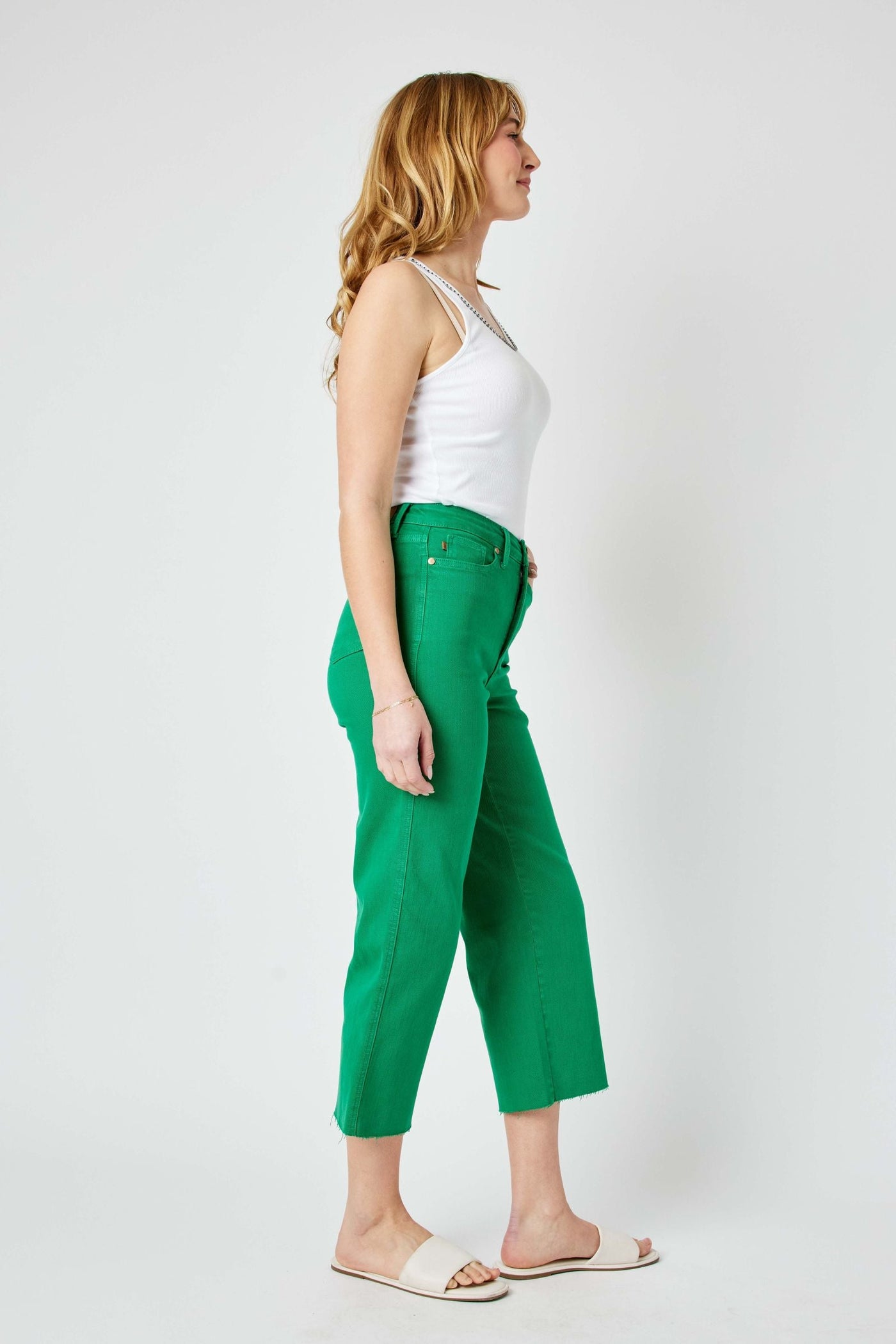 Woman wearing high waist Kelly green wide leg crop Judy Blue Jeans with tummy control and white tank top