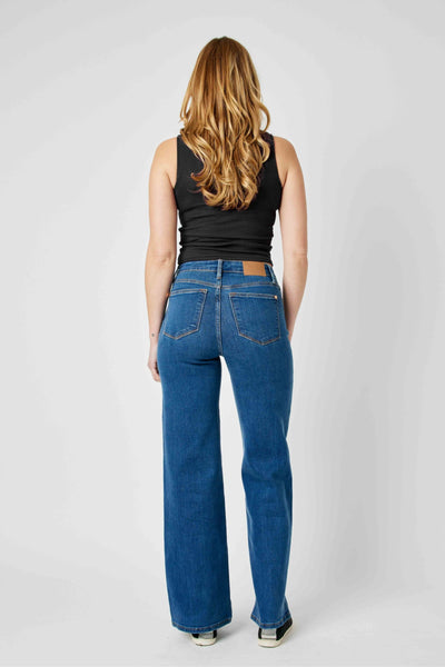 Back view of woman wearing high-waisted vintage wide-leg Judy Blue Jeans in blue denim