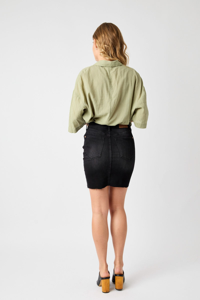 Woman wearing a high-waisted rigid black Judy Blue Skirt 2824 with destroyed detailing, shown from the back.