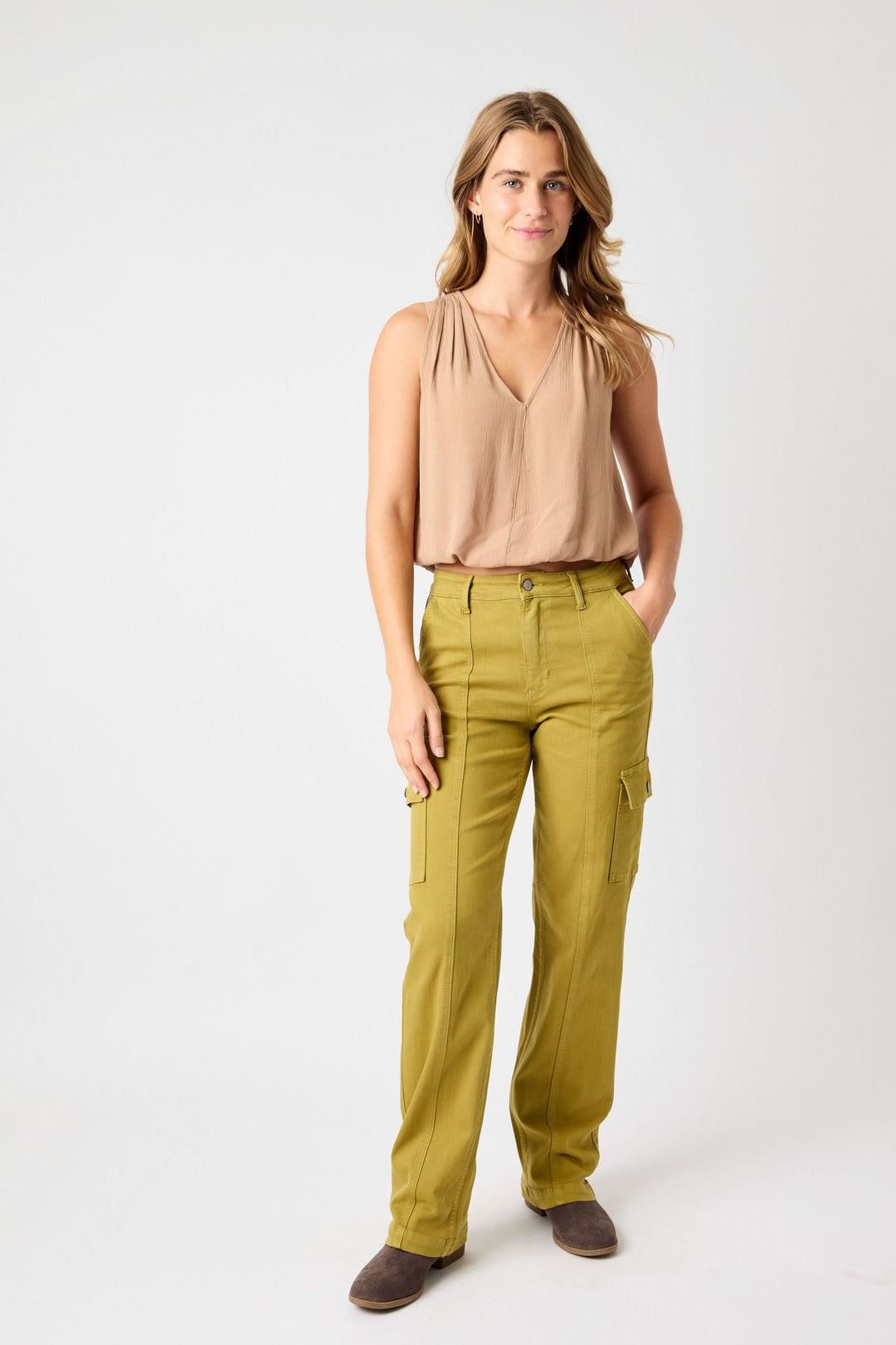 Woman wearing high waisted straight cargo Judy Blue Jeans in olive green with pockets and beige sleeveless top