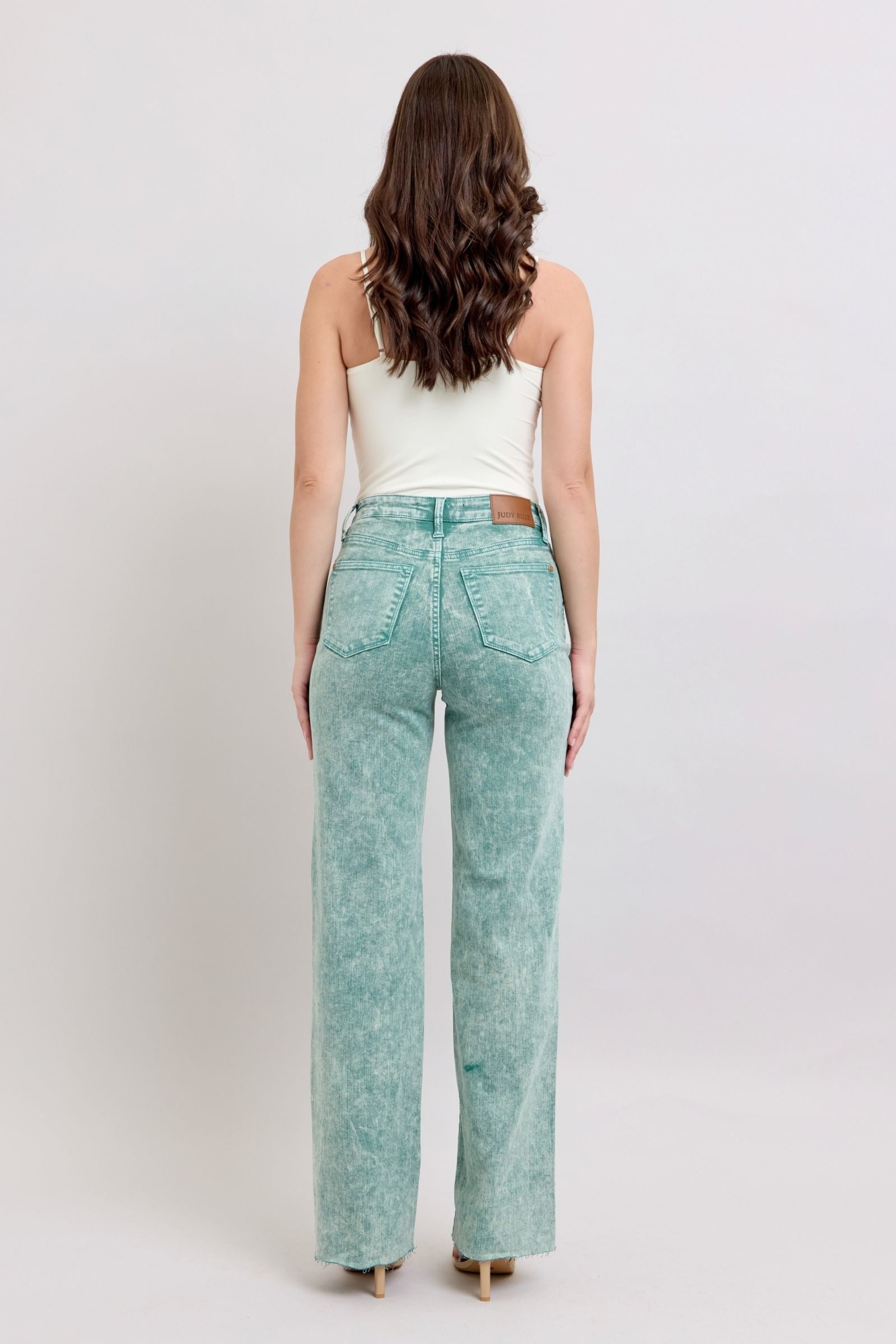 High waist sea green garment dyed jeans with relaxed fit and raw hem.