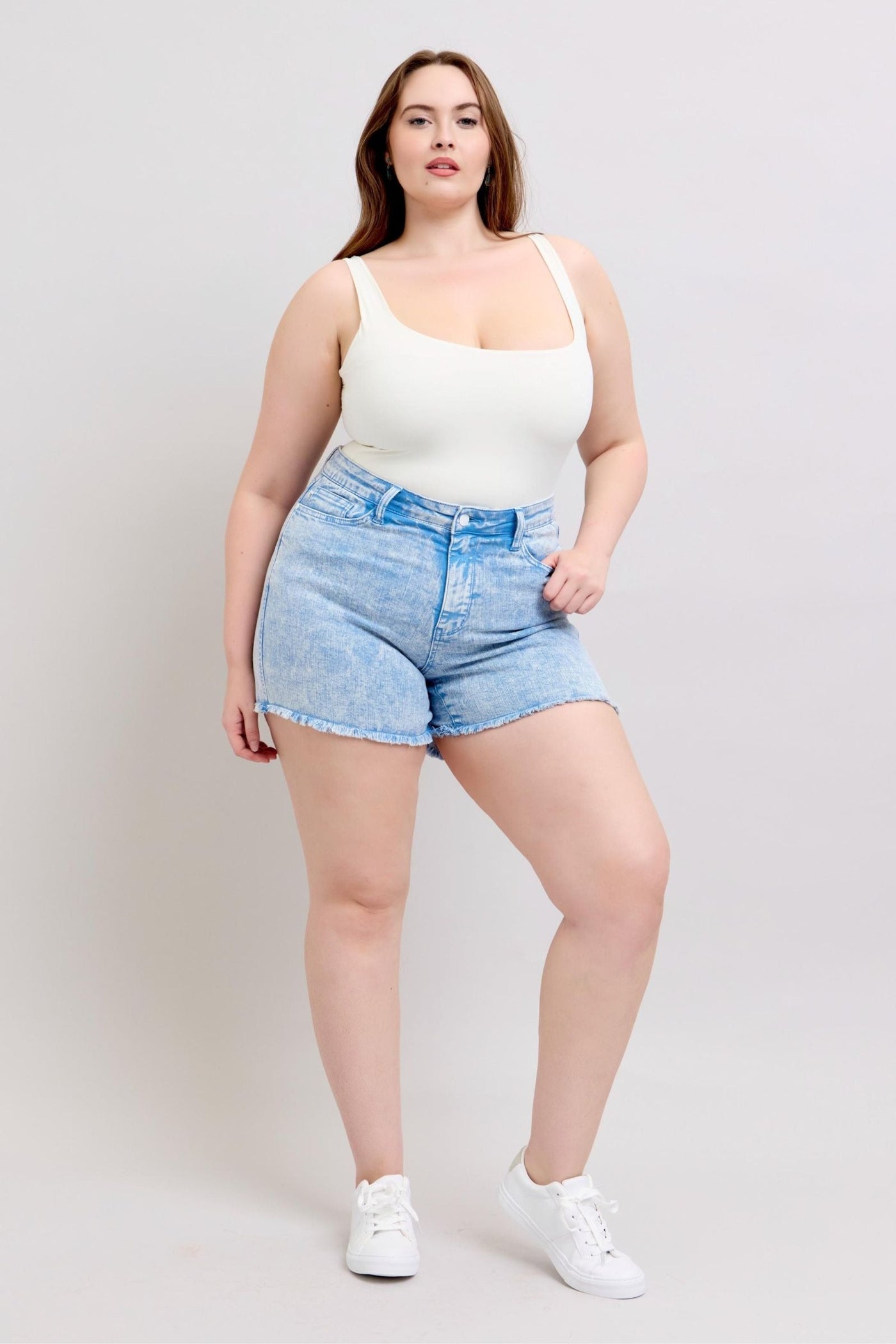 Mid-rise Judy Blue Shorts in vibrant cyan with raw hem and stretchy fabric.