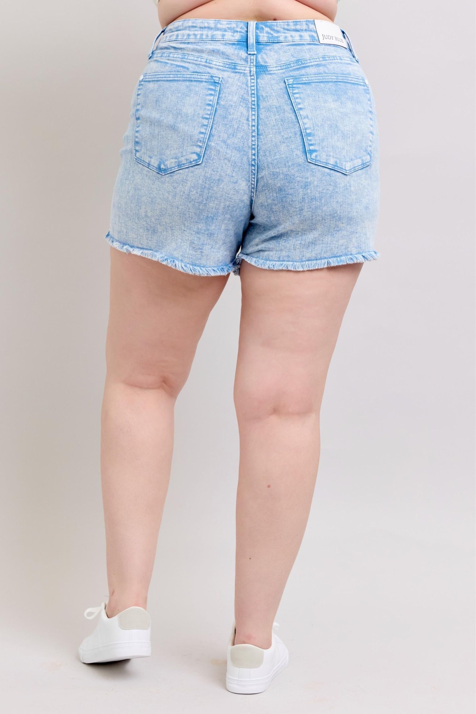 Judy Blue Shorts with mid-rise fit, vibrant cyan color, and raw hem viewed from the back.