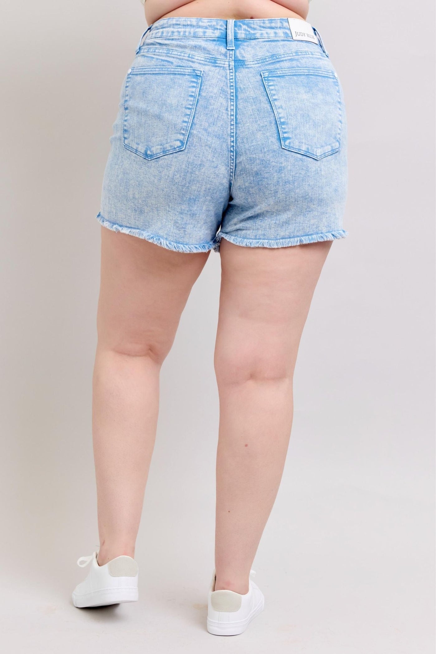 Judy Blue Shorts with mid-rise fit, vibrant cyan color, and raw hem viewed from the back.