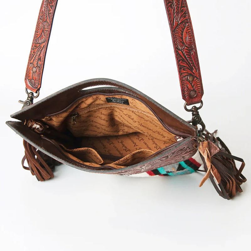 American Darling Clutch ADBG247 with hand woven wool saddle blanket, full grain leather, cowhide hair-on embellishments, leather fringes, adjustable strap, and antique metal fittings.
