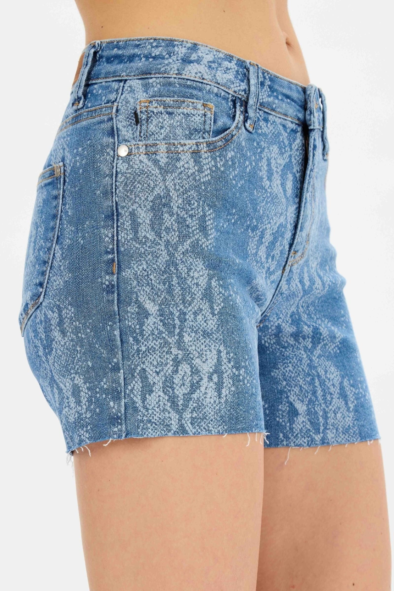 Mid-rise Judy Blue Shorts with snake print, cut-off raw hem, and 4-inch inseam.
