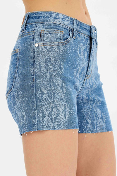 Mid-rise Judy Blue Shorts with snake print, cut-off raw hem, and 4-inch inseam.