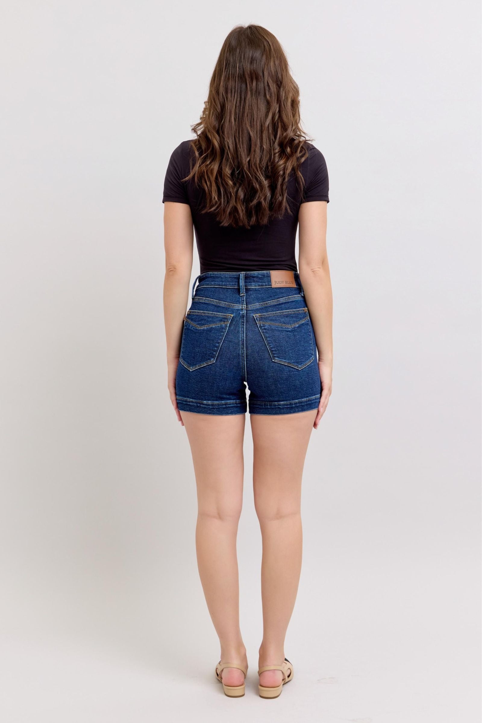 Woman wearing high waist Judy Blue denim shorts with tummy control, viewed from back