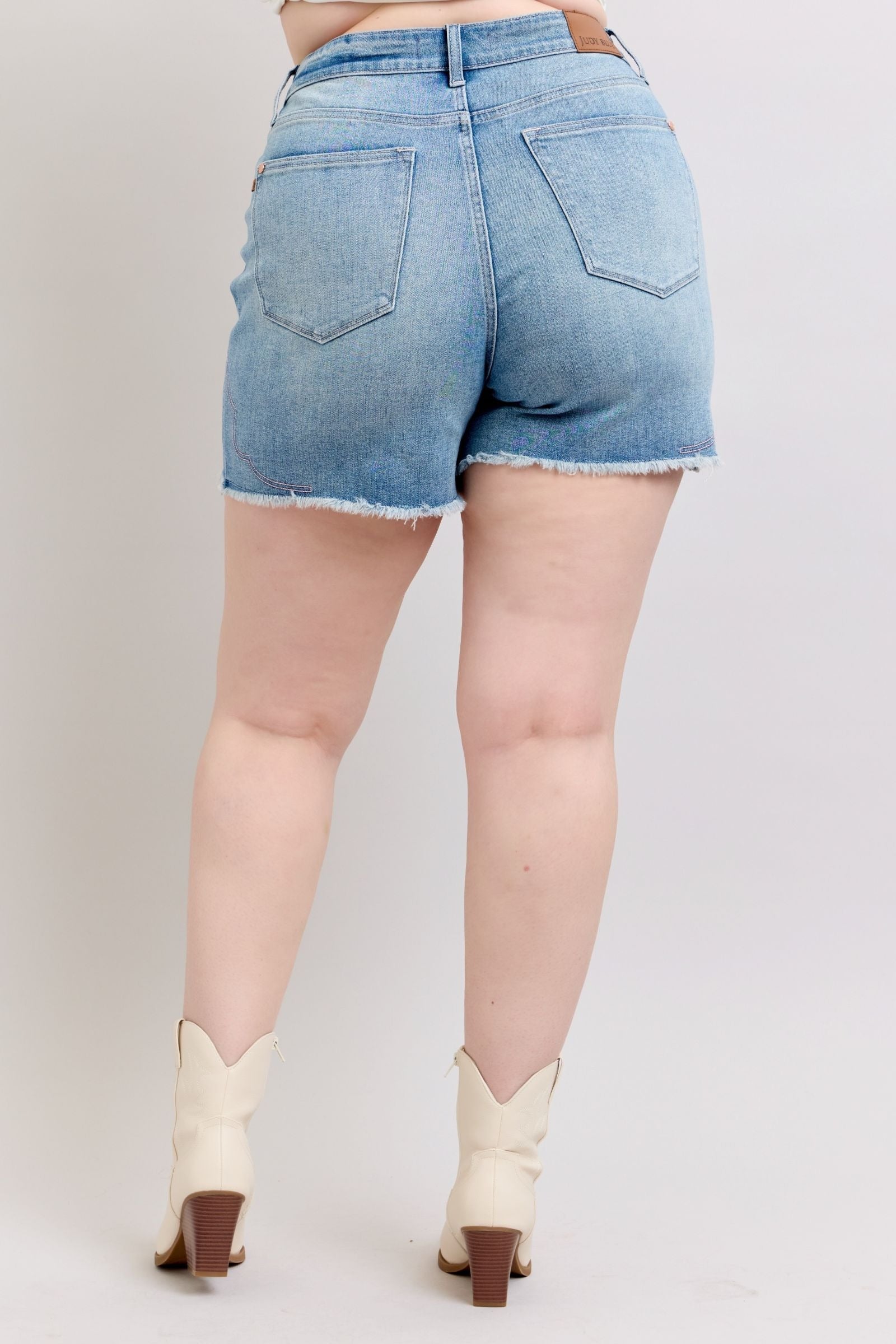 High-rise Judy Blue Shorts with raw hem and embroidery detailing.