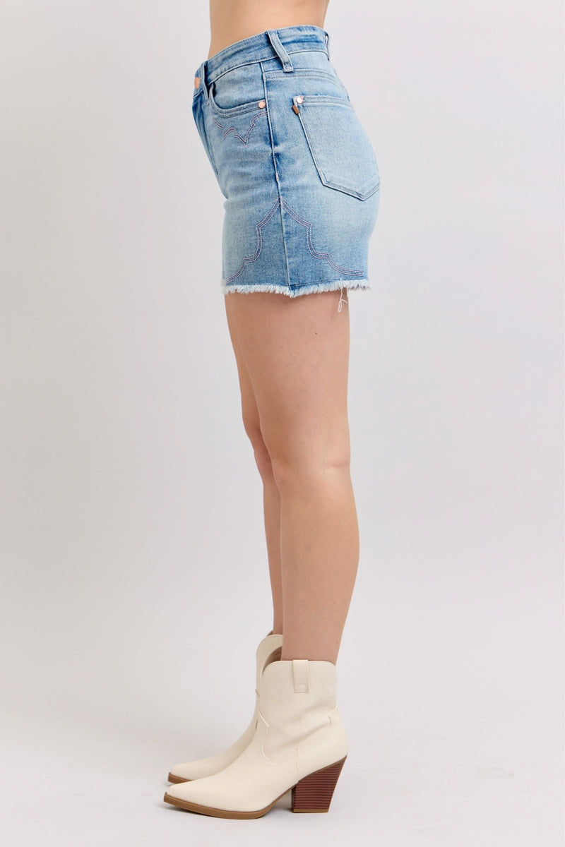 Judy Blue Shorts with high-rise cut and raw hem, side view with intricate embroidery detail.