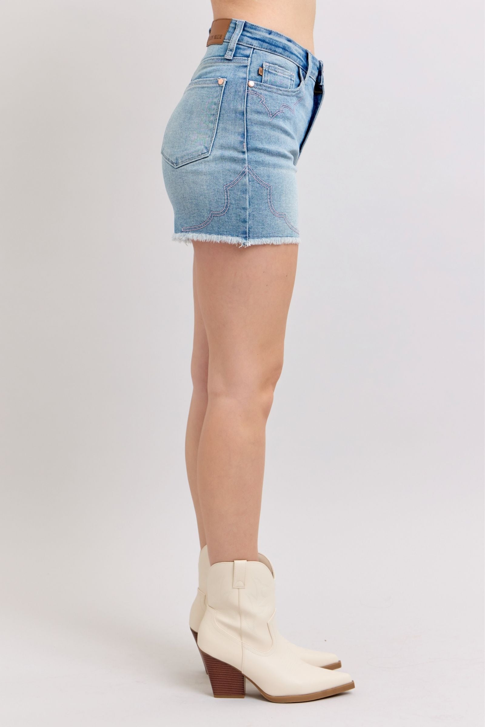 High-rise Judy Blue shorts with a raw cut-off hem, showcasing western-style embroidery and a tummy-flattering fit.