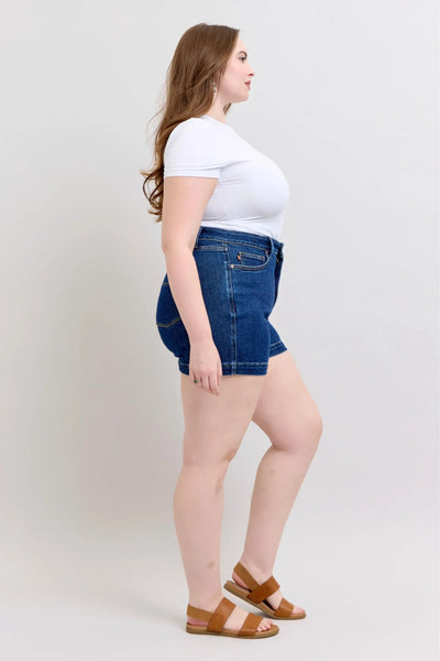 Plus size woman wearing high waist Judy Blue denim shorts with tummy control and 4.25-inch inseam