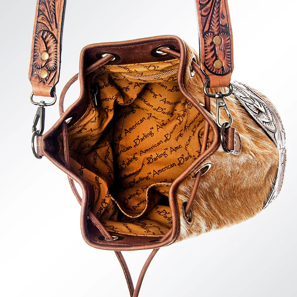 American Darling Bucket Bag ADBG569TAW crafted from hand-tooled vegetable tanned cowhide leather with adjustable shoulder strap and hair-on leather detailing