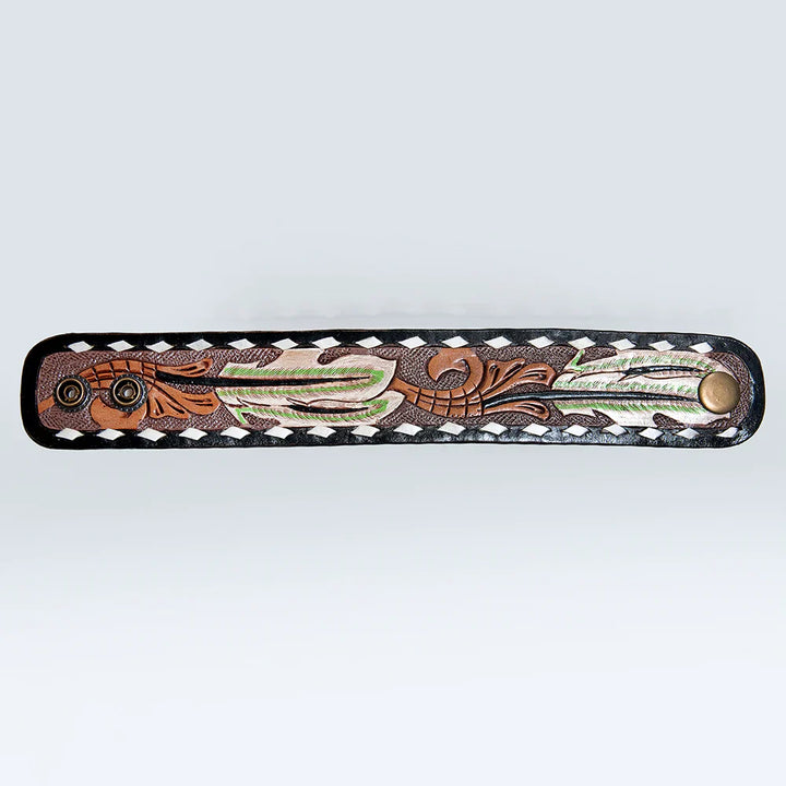 Hand-tooled American Darling Bracelet with carved feather design, black edge, white whipstitch, and dual-snap closure.