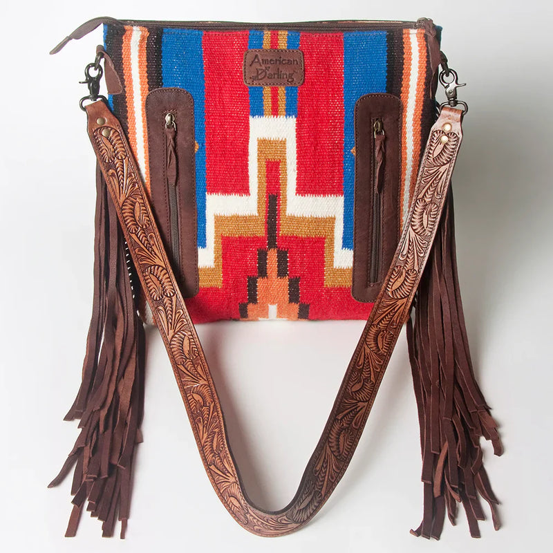 American Darling crossbody messenger bag with hand-tooled leather strap, fringes, and woven wool saddle blanket in vibrant western design