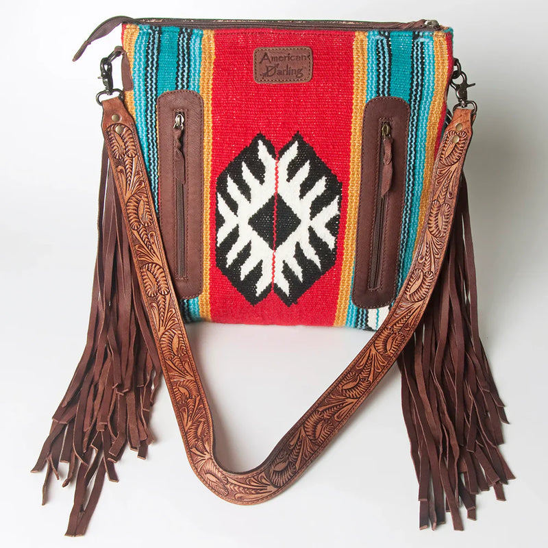 American Darling Crossbody Messenger Bag ADBGZ581 with hand-tooled leather strap, fringes, and colorful woven wool saddle blanket design