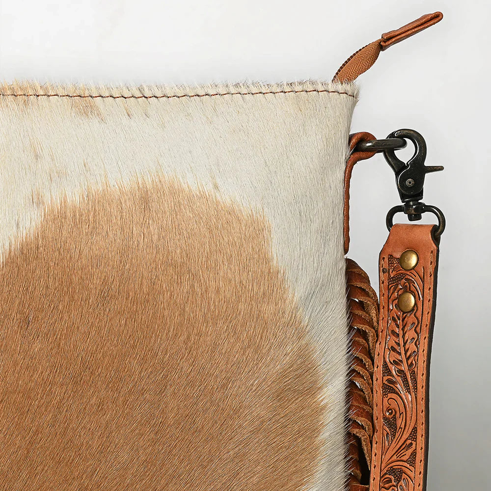 Close-up of American Darling Messenger bag ADBGS192TAW showing hair-on cowhide leather, hand-tooled vegetable tanned leather strap, and stainless steel snap hook.