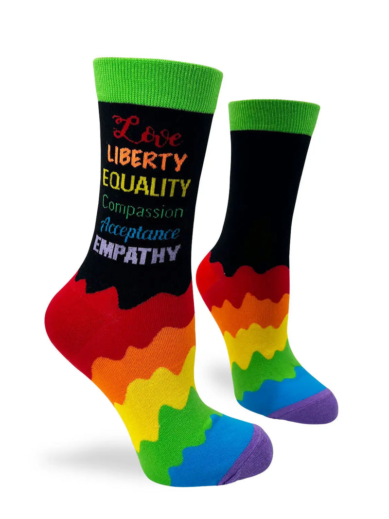 Colorful crew socks with green cuffs featuring the words "Love Liberty Equality Compassion Acceptance Empathy" in vibrant colors and a rainbow pattern on the lower half.