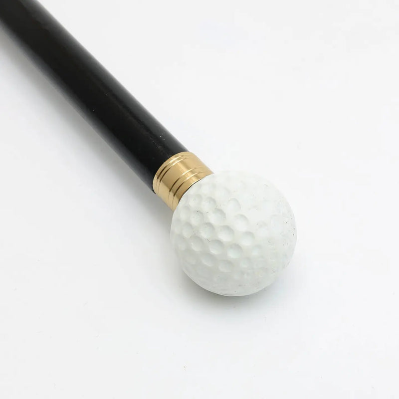 Close-up of black wooden long shoehorn with metal handle and white golf ball-shaped end